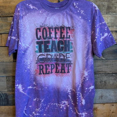 Purple tie-dye t-shirt with text on a wooden surface