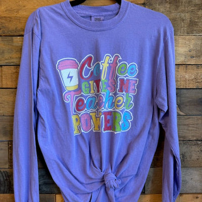 Purple long-sleeve shirt with colorful text design on a wooden surface