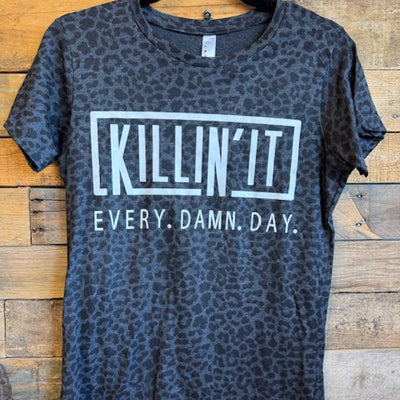 Gray leopard print t-shirt with text on a wooden surface