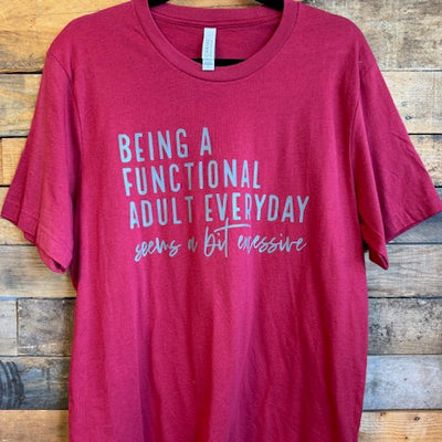 red t-shirt with white text on a wooden surface