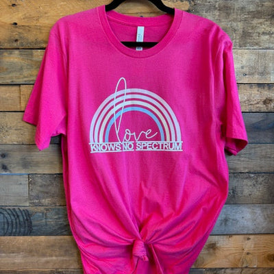 Pink t-shirt with a logo on a wooden surface