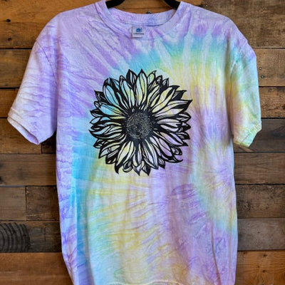 Tie-dye t-shirt with a black sunflower design on a wooden surface