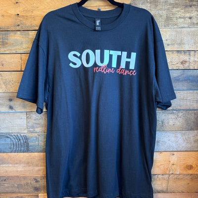 black t-shirt with 'SOUTH' printed on it, on a wooden surface