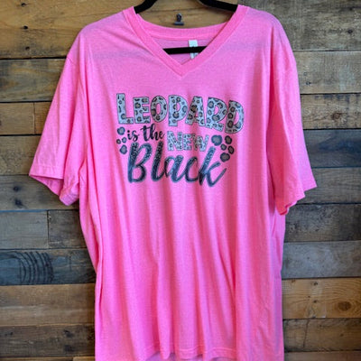 Pink t-shirt with text on a wooden surface