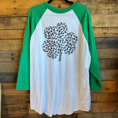 Green and white t-shirt with black pattern on wooden surface