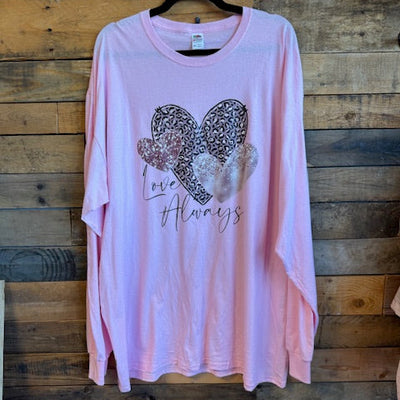 Pink t-shirt with decorative heart design on a wooden surface
