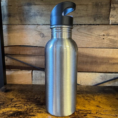 Silver water bottle with a cap on a wooden surface