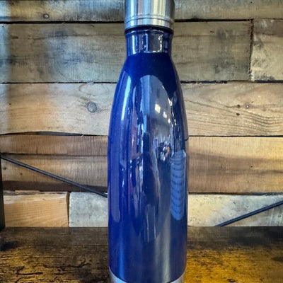 Blue water bottle with silver cap on a wooden surface