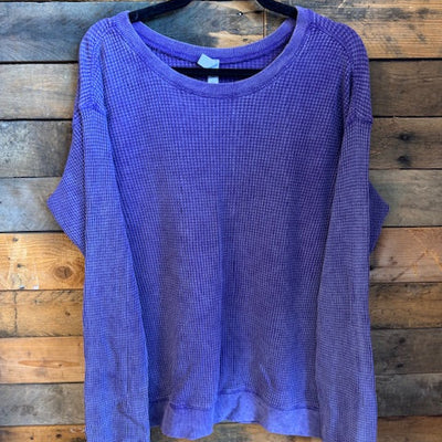 Purple long-sleeve shirt on a wooden surface