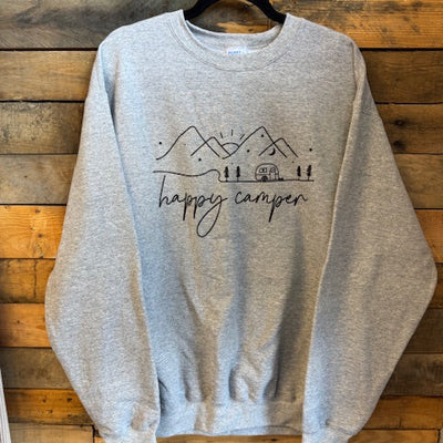Gray sweatshirt with 'happy camper' text on a wooden surface