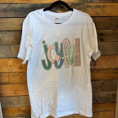 White t-shirt with colorful text design on a wooden surface