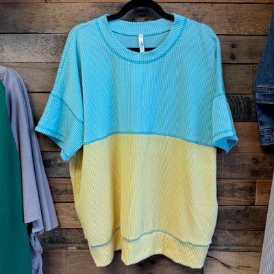 blue and yellow sweater on a wooden surface