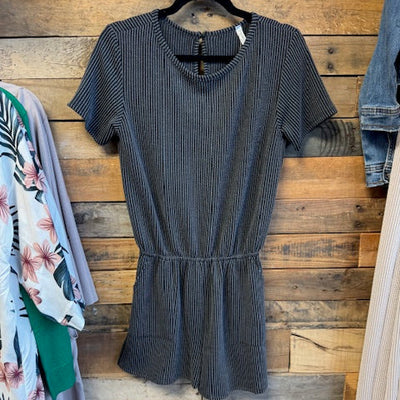 Black ribbed romper on a wooden surface