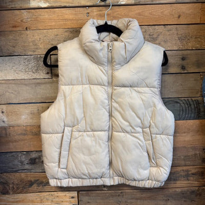 Beige puffer vest on a wooden background