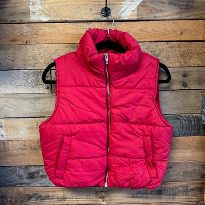 Red puffer vest on a wooden surface