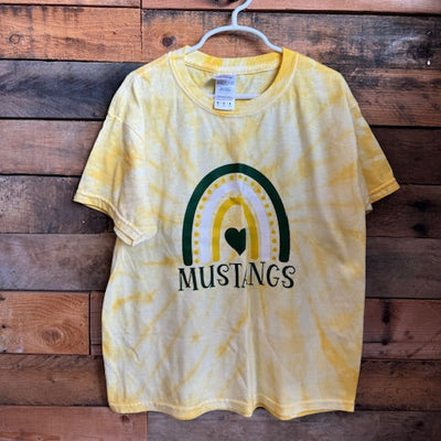 Yellow tie-dye t-shirt with 'Mustangs' logo on a wooden surface
