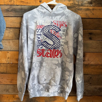 Gray sweatshirt with red and blue text and graphics on a wooden surface