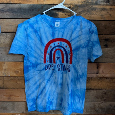 Blue tie-dye t-shirt with a red and white logo on a wooden surface
