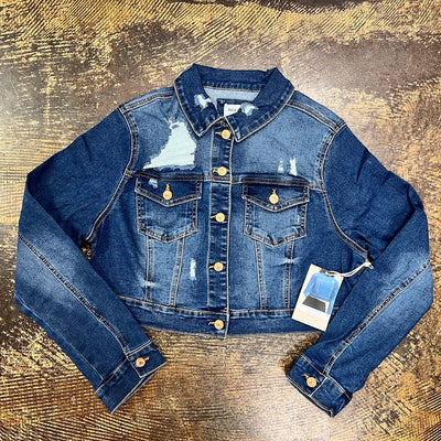 Blue denim jacket with a tag on a textured gold surface